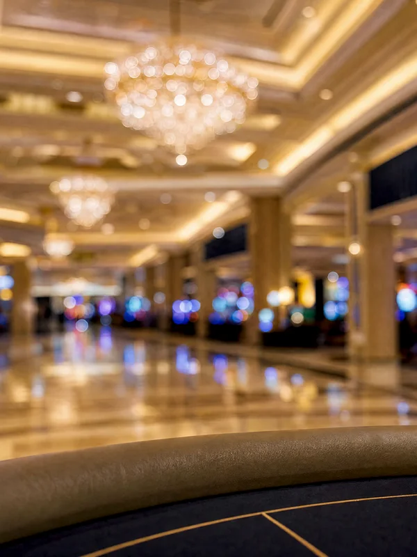 Illustrative image — a wide casino hall with gaming tables and slot lights